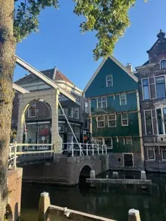 A white wooden drawbridge beside a green timber house in Alkmaar