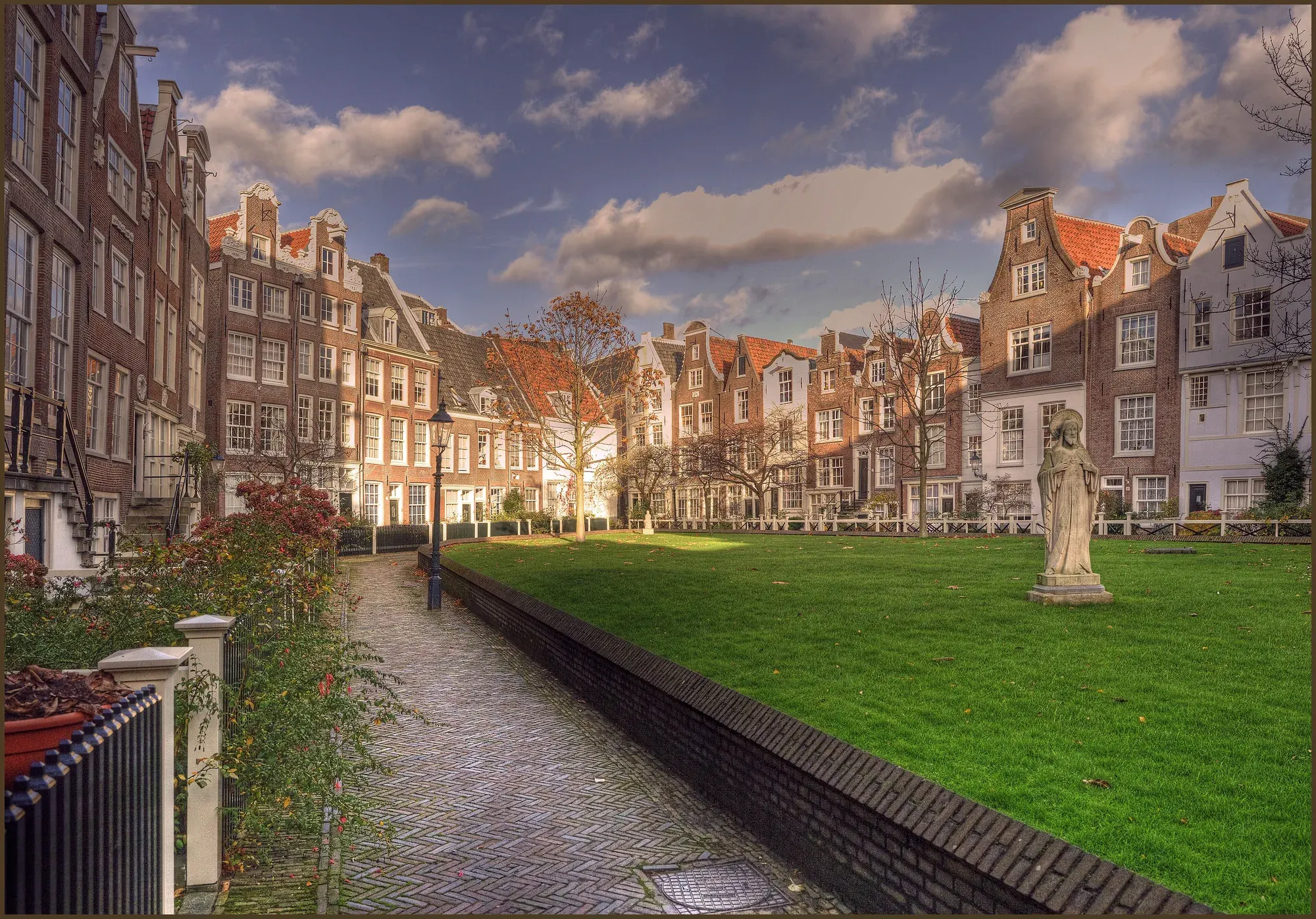 The quiet Begijnhof courtyard in Amsterdam, ringed by low historic houses and a lawn