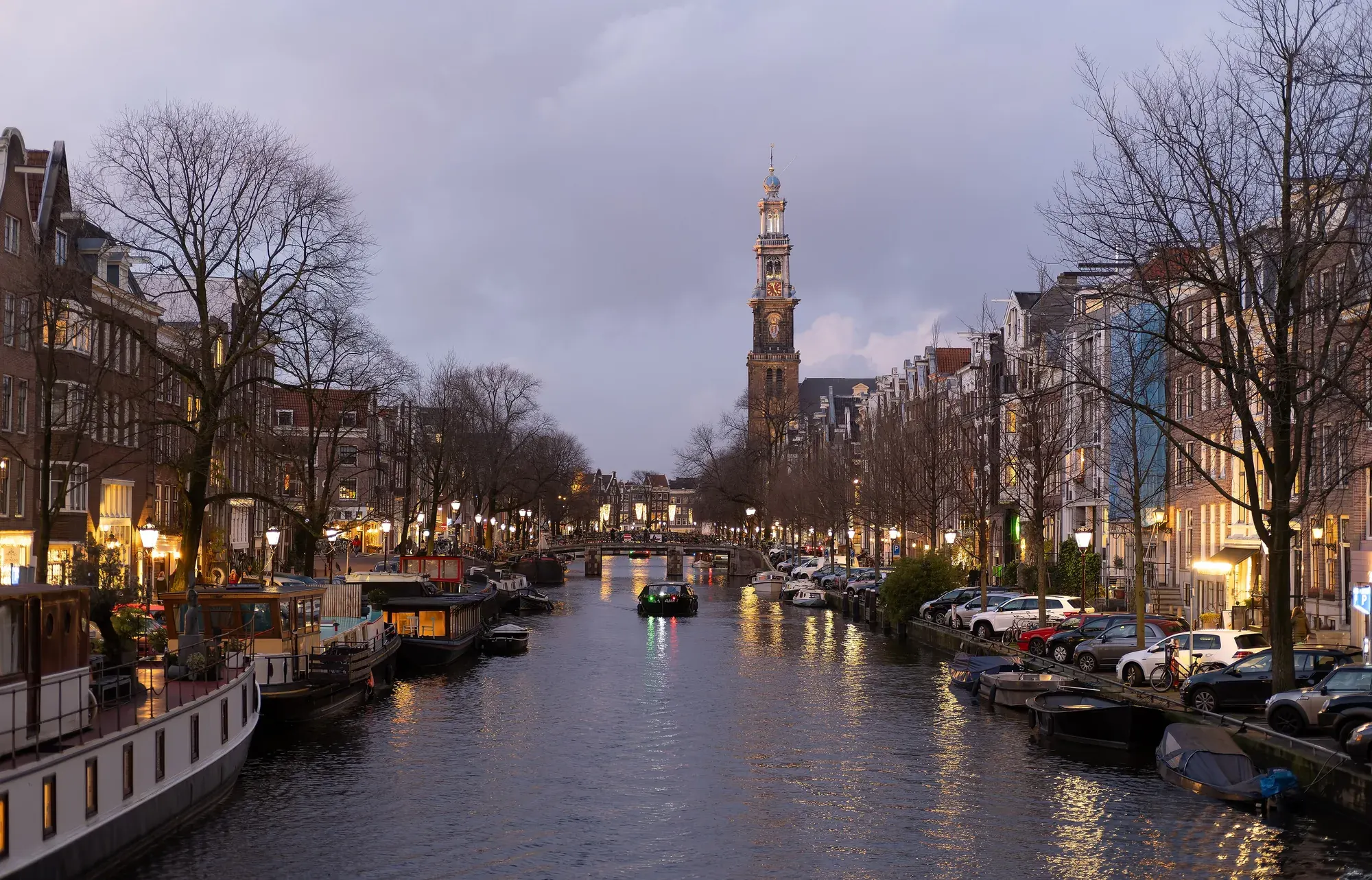 The Prinsengracht canal in Amsterdam with the tower of the Westerkerk rising behind the gabled houses
