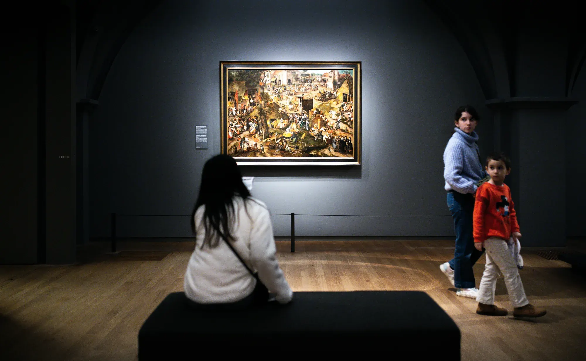 Visitors looking at a 16th-century painting in the Rijksmuseum, Amsterdam