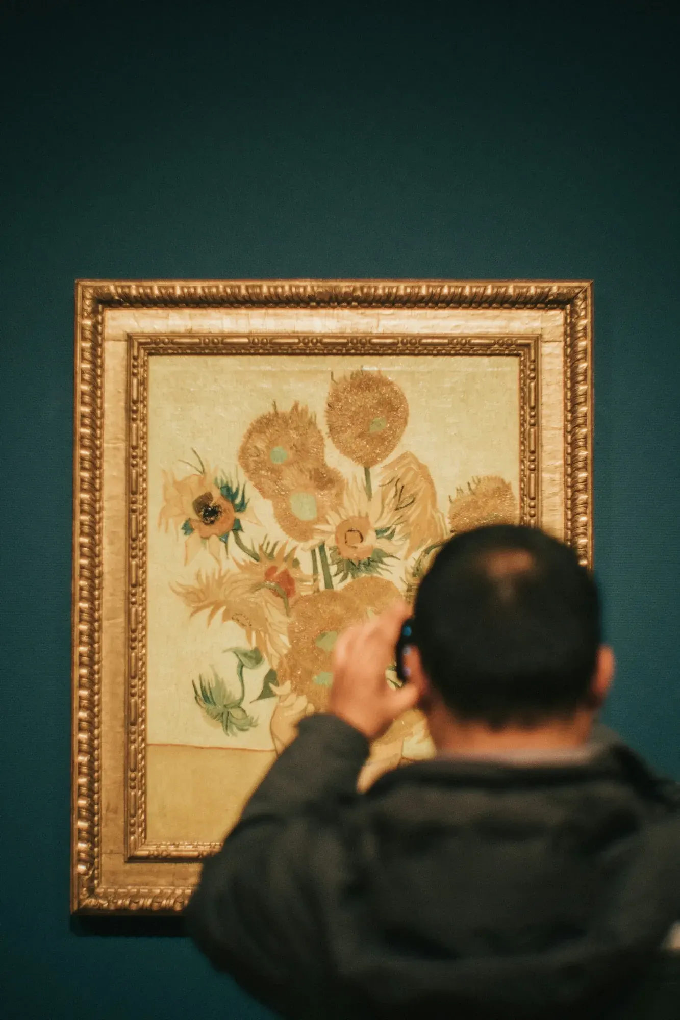 A visitor photographing Van Gogh's Sunflowers in the Van Gogh Museum, Amsterdam