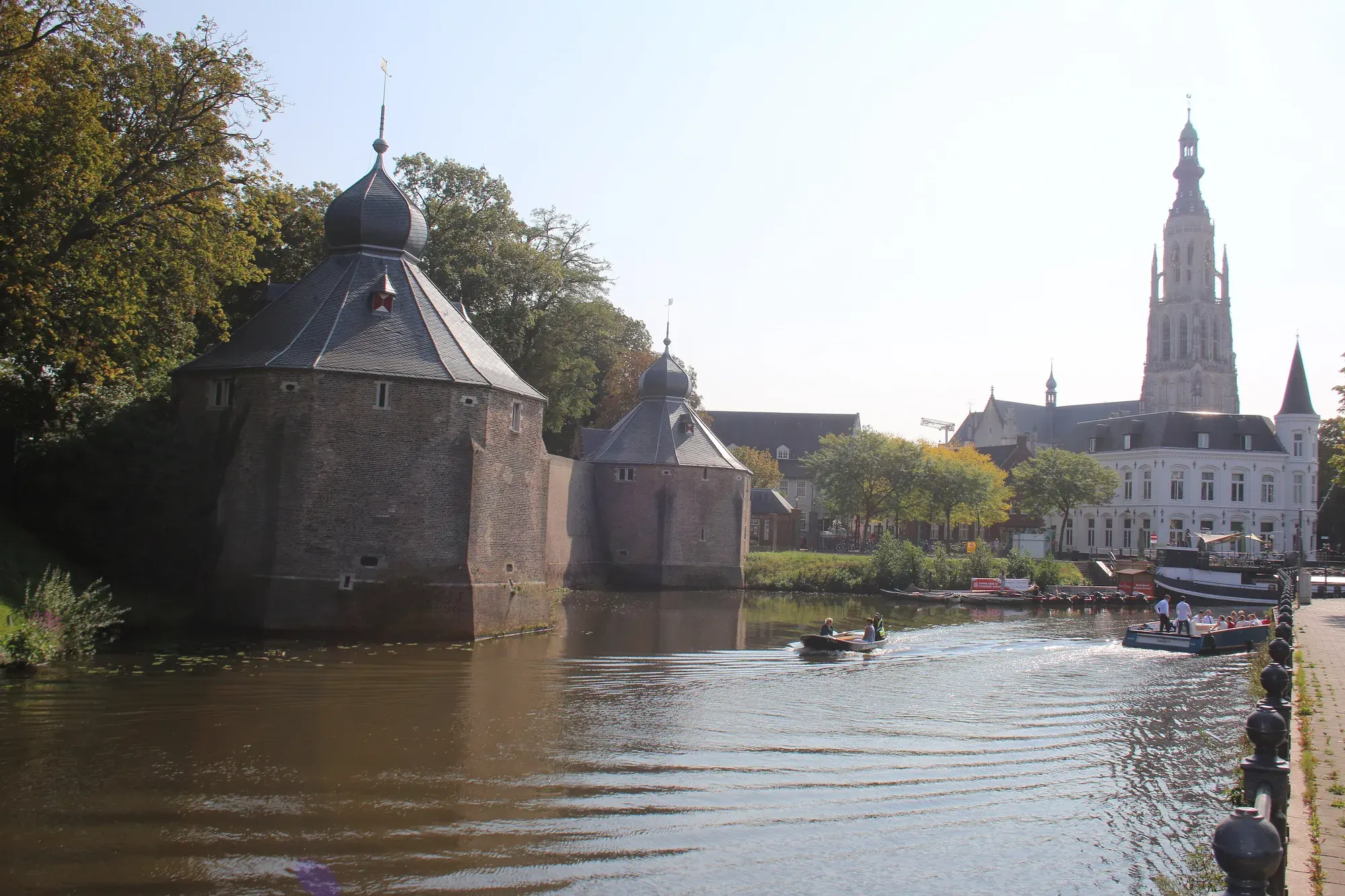 The twin towers of the Spanjaardsgat on the water in Breda, with the tower of the Grote Kerk behind