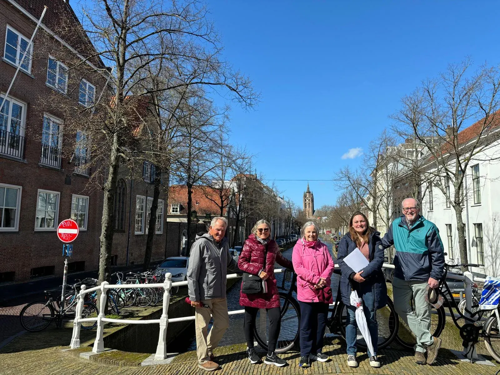 A small private tour group with their guide on a canal bridge in Delft