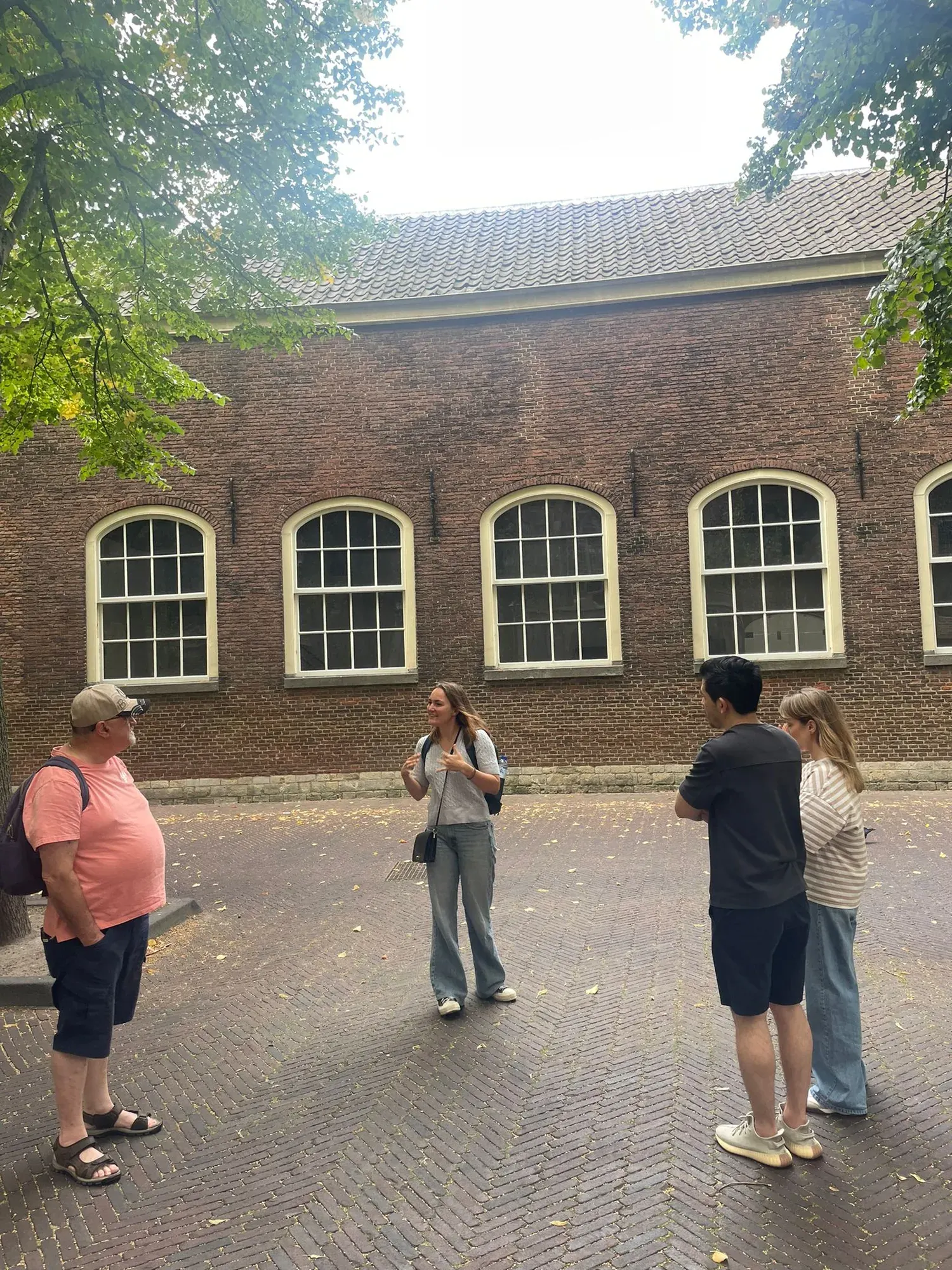 A guide with a small private group in the Prinsenhof courtyard, Delft