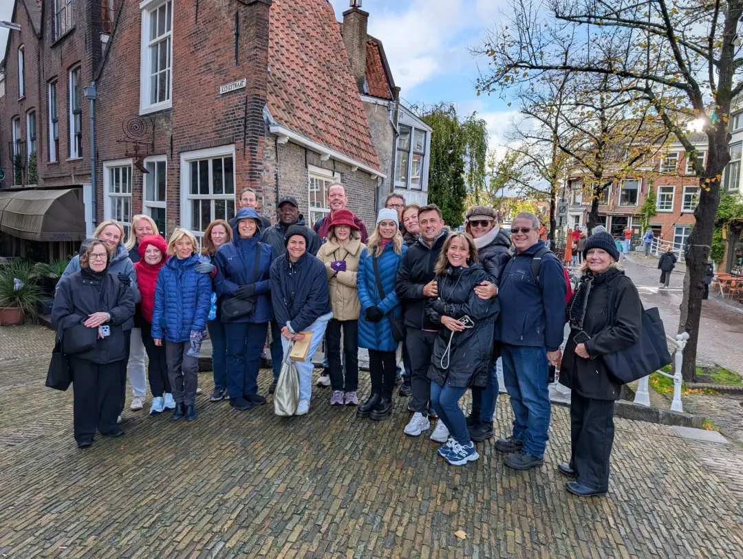 Ein Gruppenfoto in der Kerkstraat in Delft, dahinter die alten Backsteinhäuser