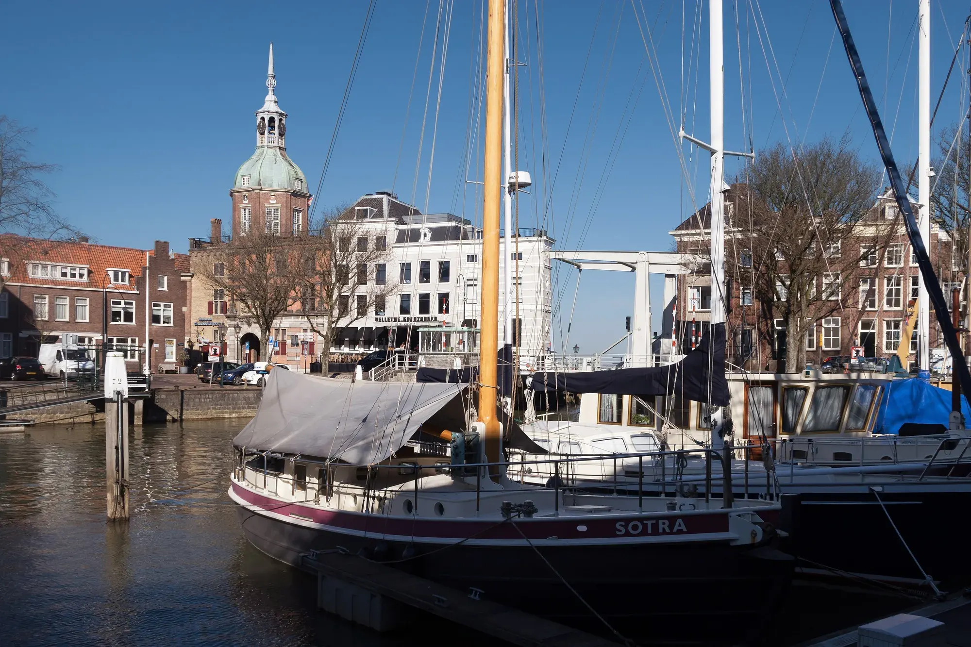 Traditional barges moored at the Taankade in Dordrecht with the domed tower of the Groothoofdspoort behind