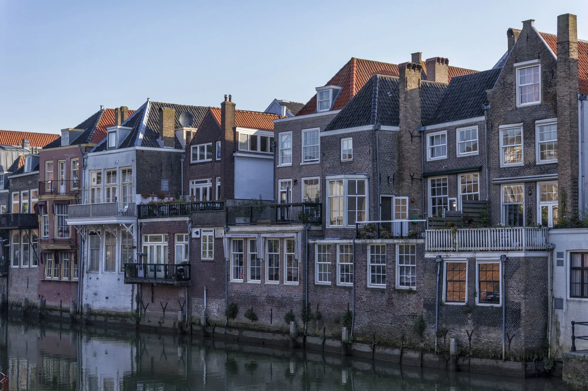 Tall brick houses standing straight in the water along the Voorstraathaven in Dordrecht