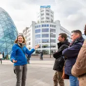 A city guide explaining the Blob and the Philips Lichttoren to a private tour group, Eindhoven