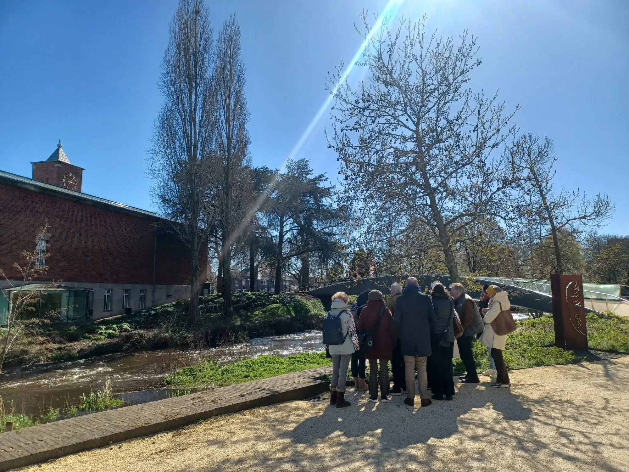 A tour group gathered by a footbridge over the river Dommel, Eindhoven