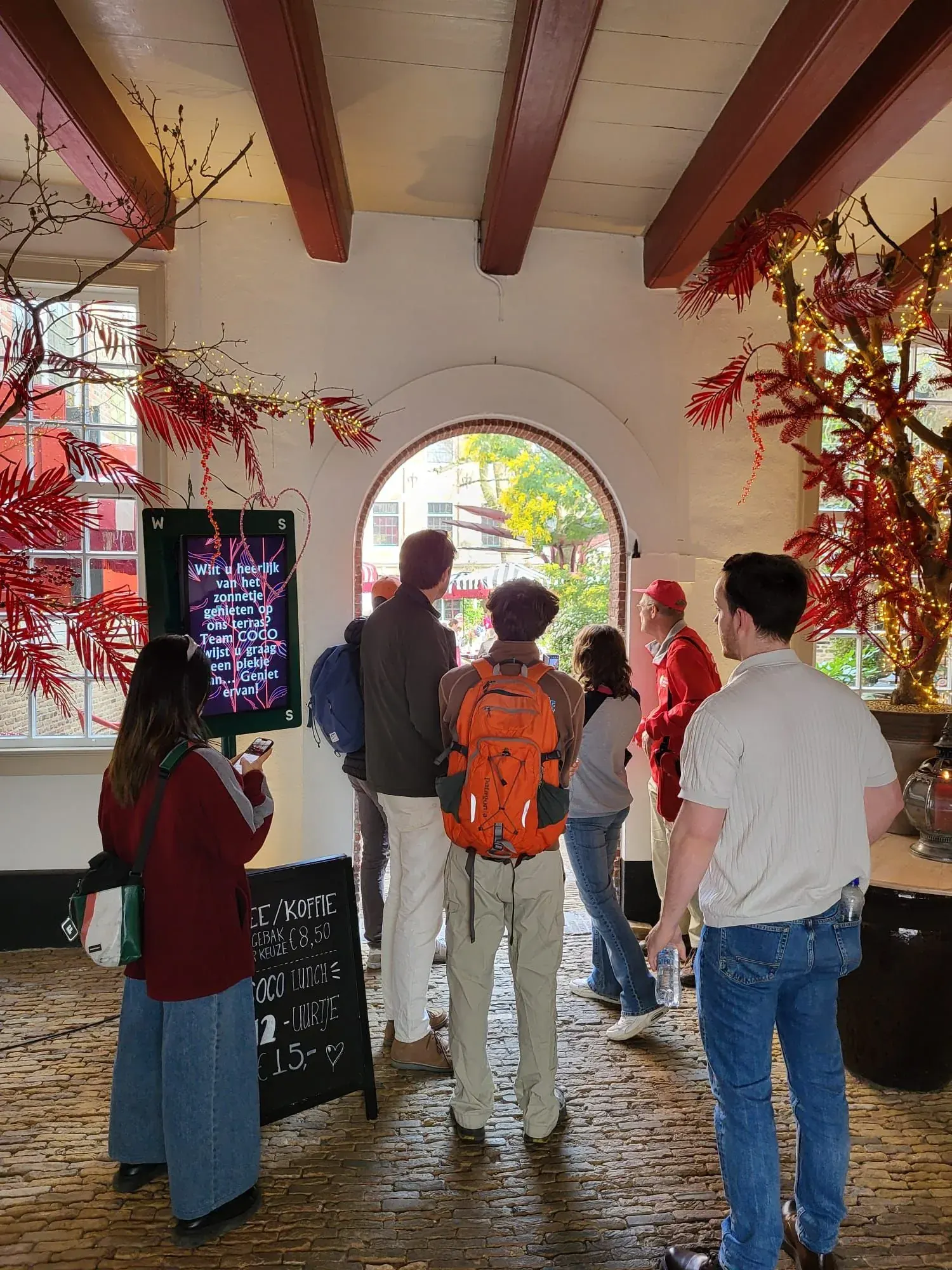 A tour group passing through a historic covered archway, Gouda