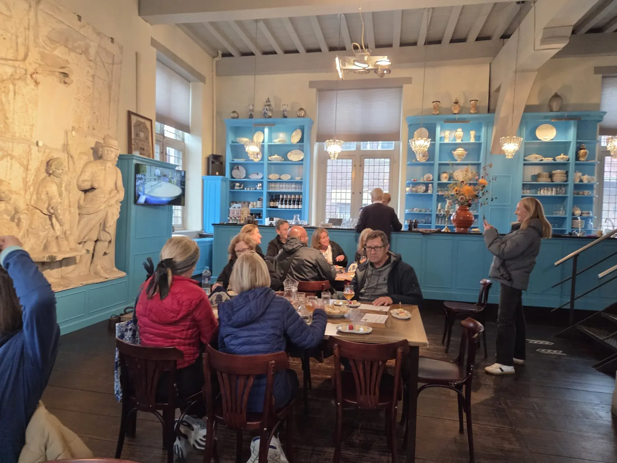 Eine Gruppe bei der Käseverkostung im blauen Probierraum der Goudse Waag, Gouda