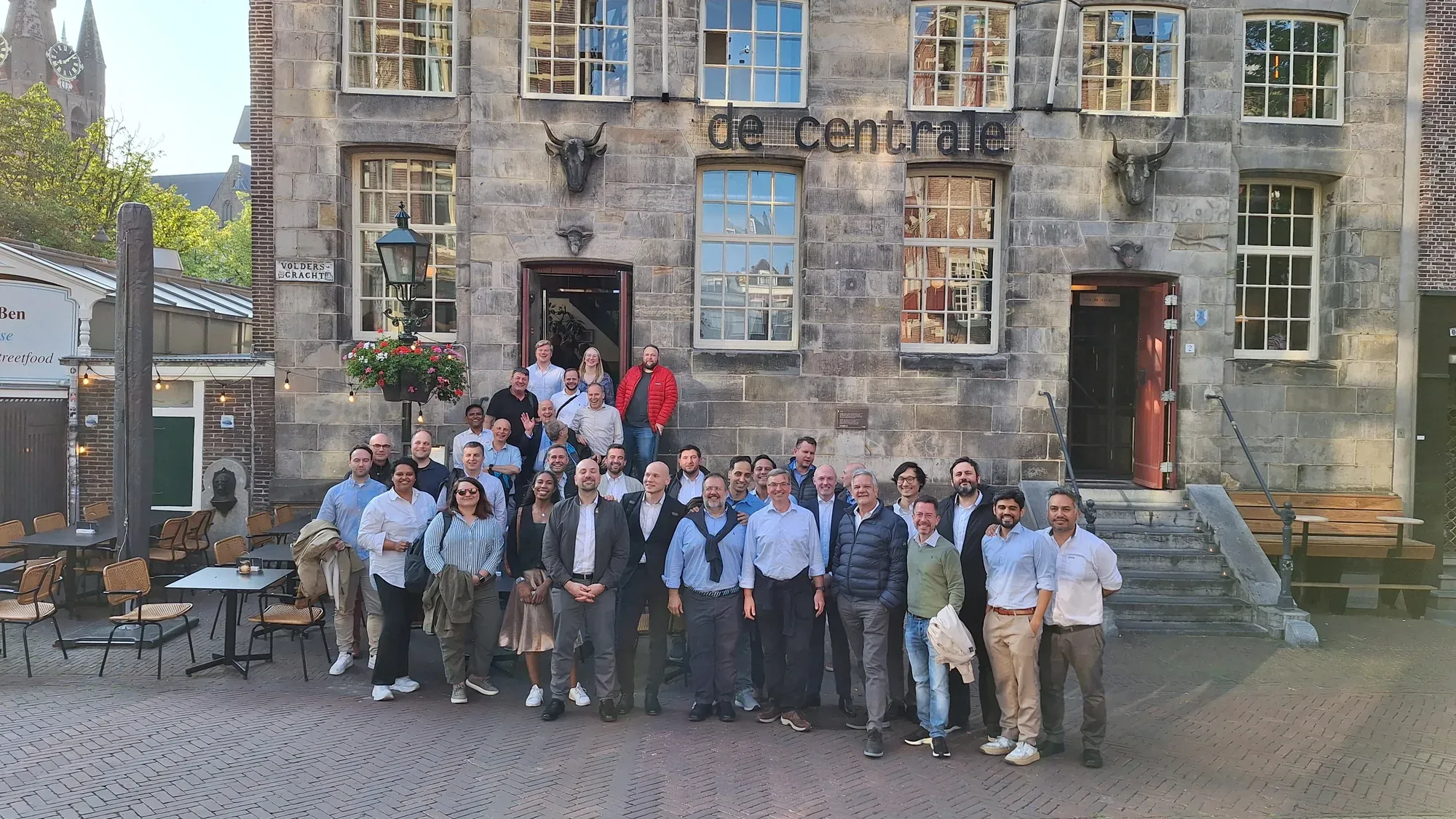 A large group of guests posing in front of restaurant De Centrale in Delft