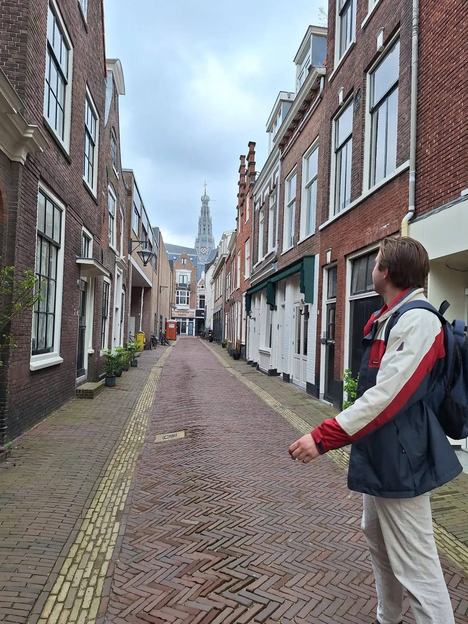 A narrow cobbled Haarlem street with the Bavokerk tower at the far end