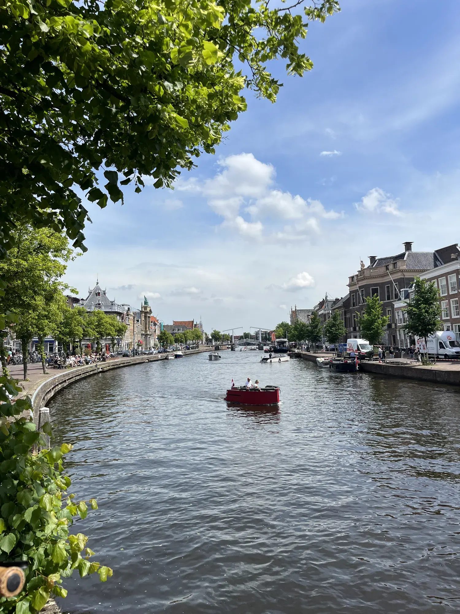 A small red boat on the river Spaarne seen from the quay, Haarlem