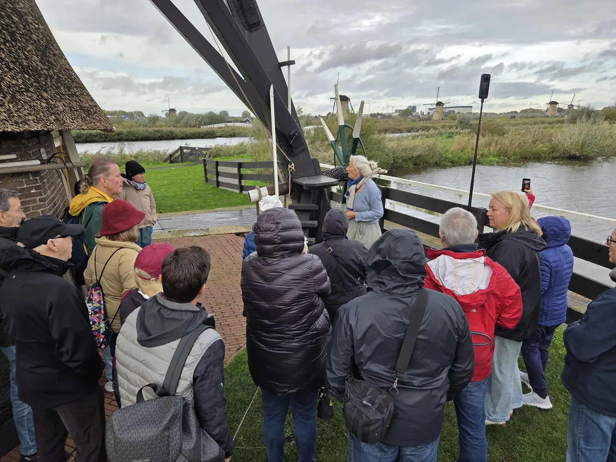 Der Müller mit einer Gruppe unter den Flügeln einer Windmühle in Kinderdijk