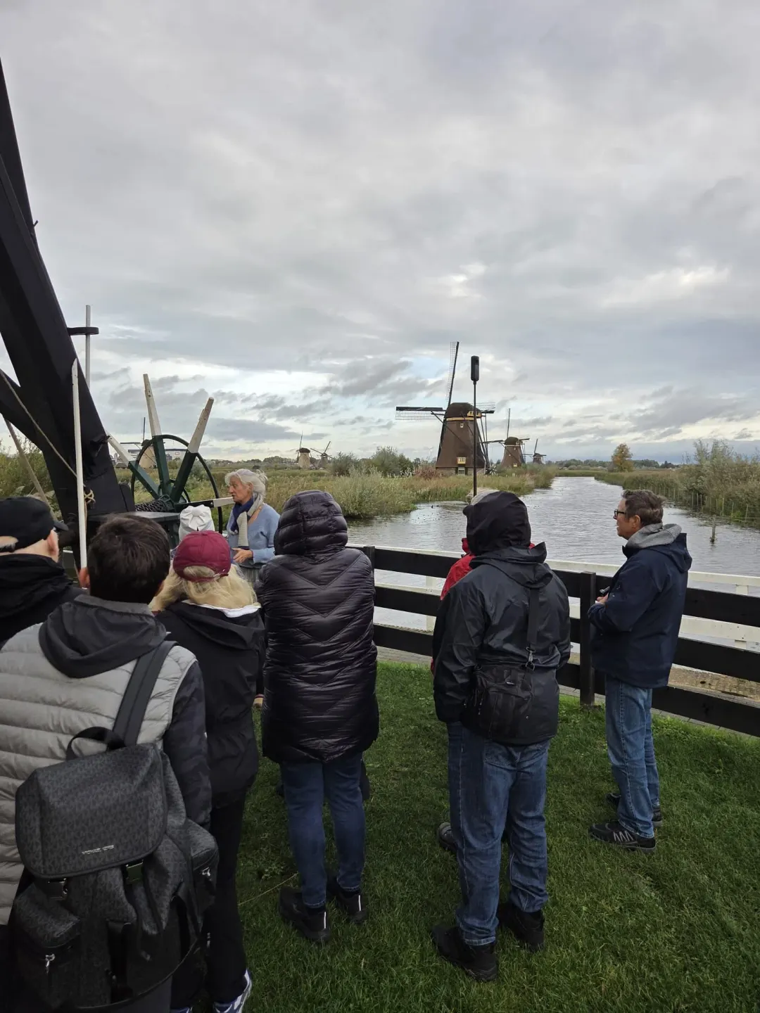 Eine Gruppe mit dem Müller vor den Windmühlen am Kanal in Kinderdijk