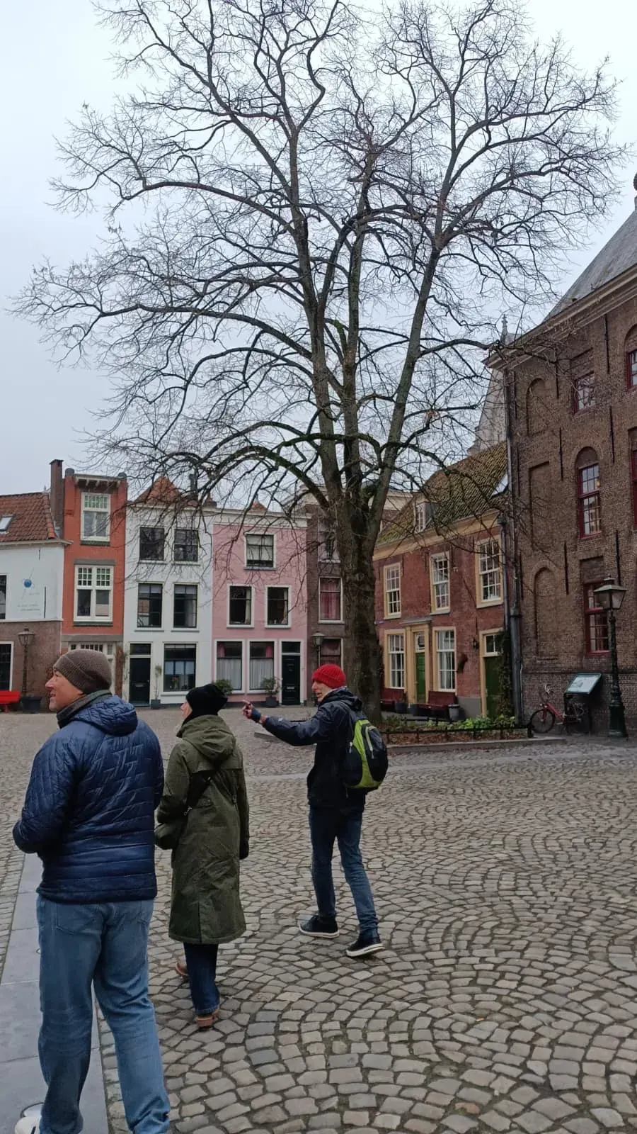 A group in the Pieterskerkhof in Leiden with colourful houses behind