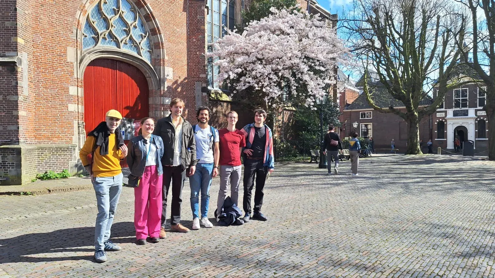A guide and tour group walking a historic street in Leiden