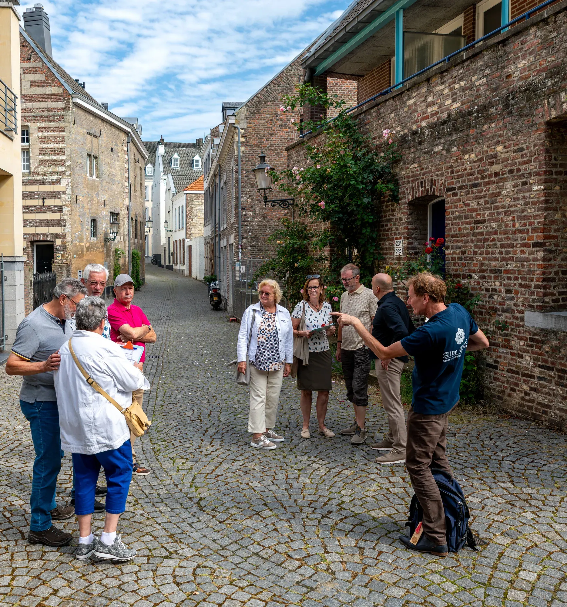 A guide leading guests along a cobbled lane in the Stokstraat quarter, Maastricht