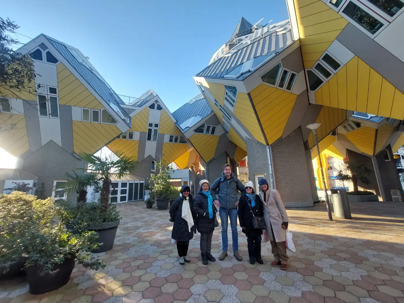 A group with a guide posing in front of the Cube Houses in Rotterdam.