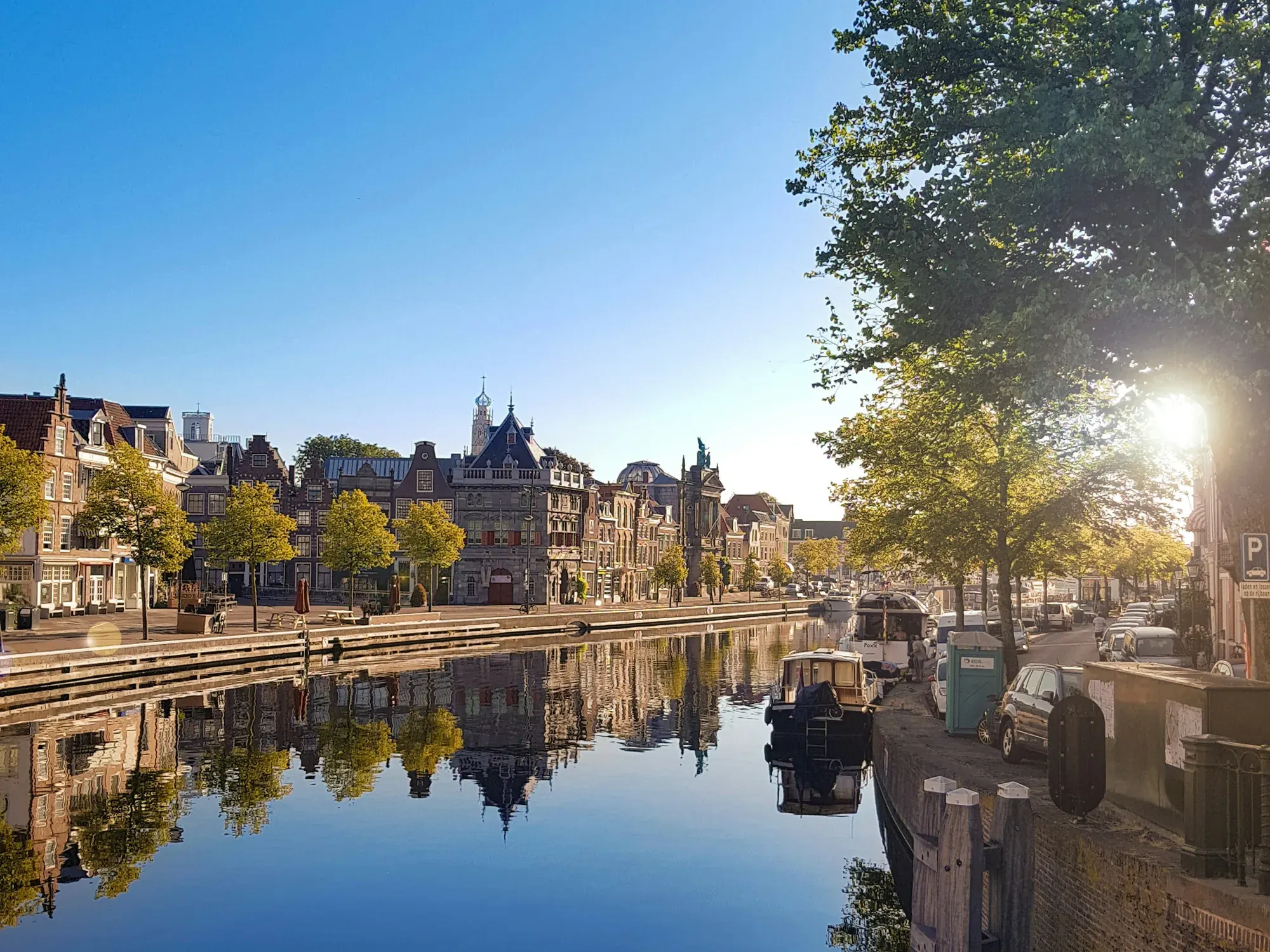 De Waag and the Spaarne quay mirrored in the still river on a sunny morning in Haarlem