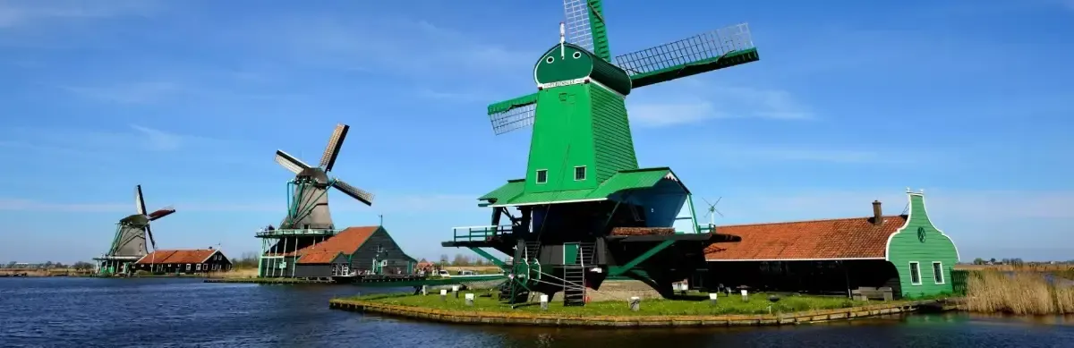 The green wooden windmills of the Zaanse Schans along the water