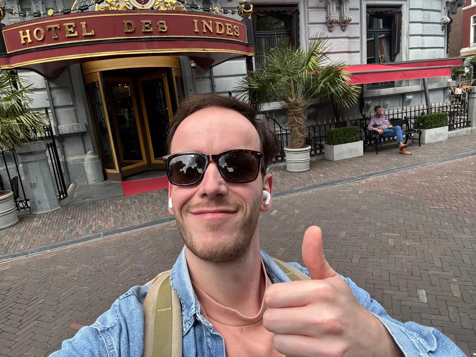 A listener with earphones in outside Hotel Des Indes in The Hague