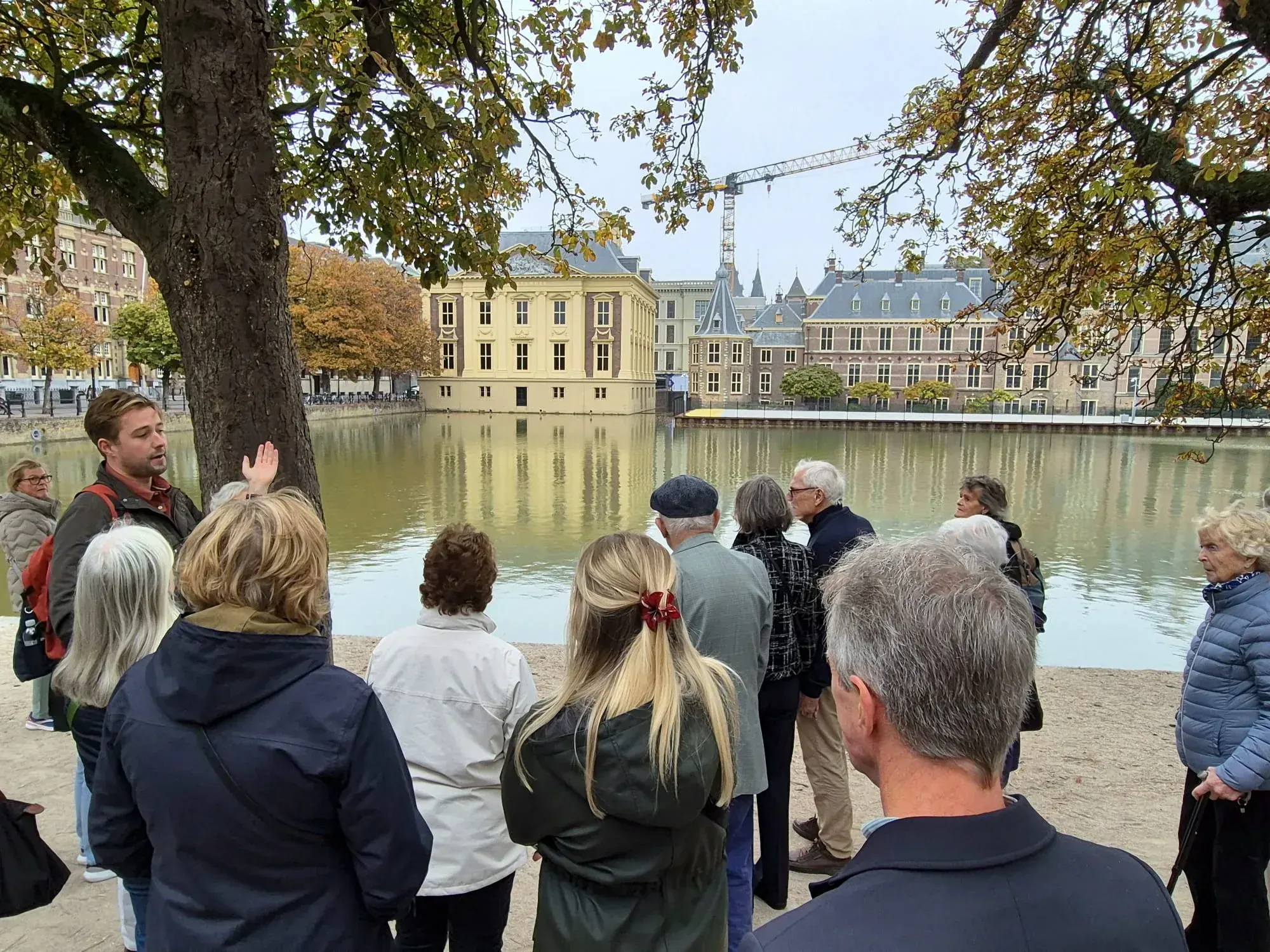 A guide and group looking across the Hofvijver to the Mauritshuis, The Hague