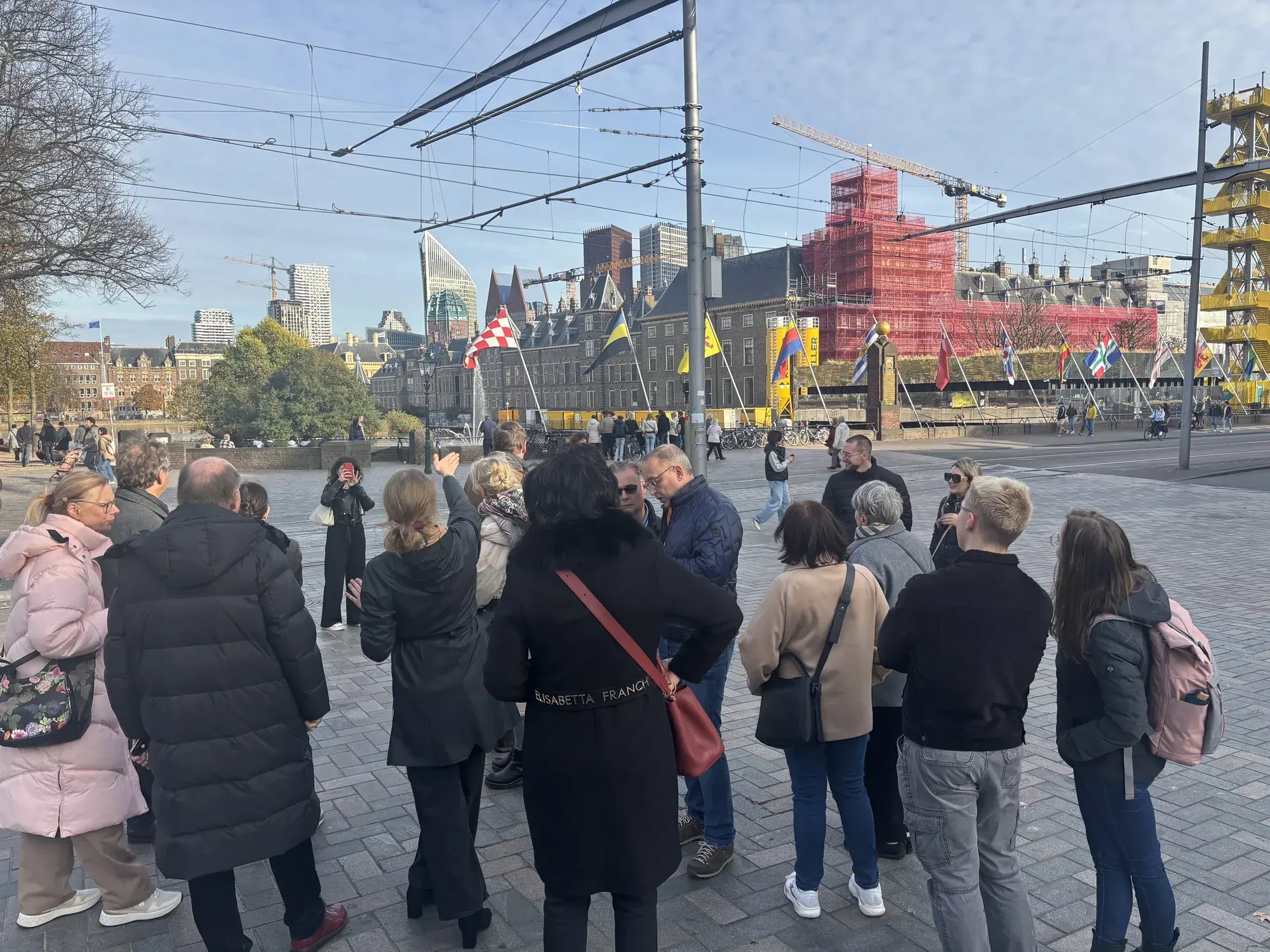 A tour group near the Binnenhof with international flags behind them, The Hague