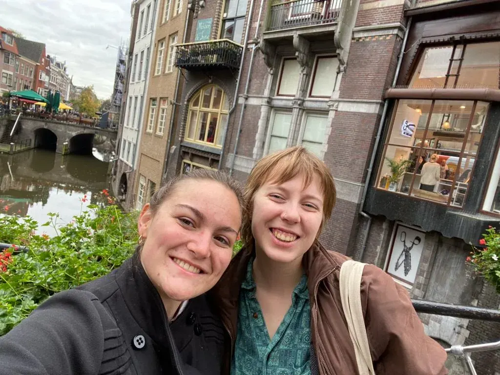 A guide and a guest smiling on a bridge over a Utrecht canal