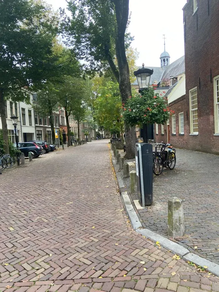 A quiet cobbled Utrecht street with a small church tower at the end